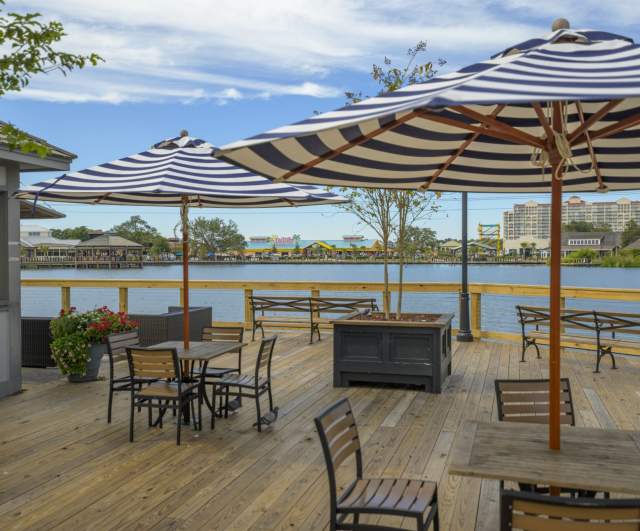 Umbrellas and tables overlooking the water at Barefoot Landing