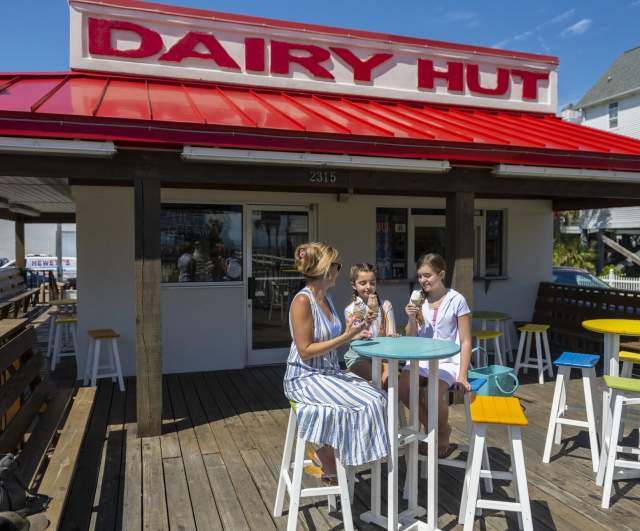 A mom and her two daughters enjoy soft serve ice cream outside of Dairy Hut in Cherry Grove.