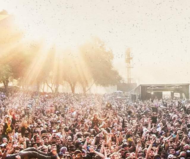 the back of someone on stage pointing out at a large crowd at the aftershock fesitval in sacramento