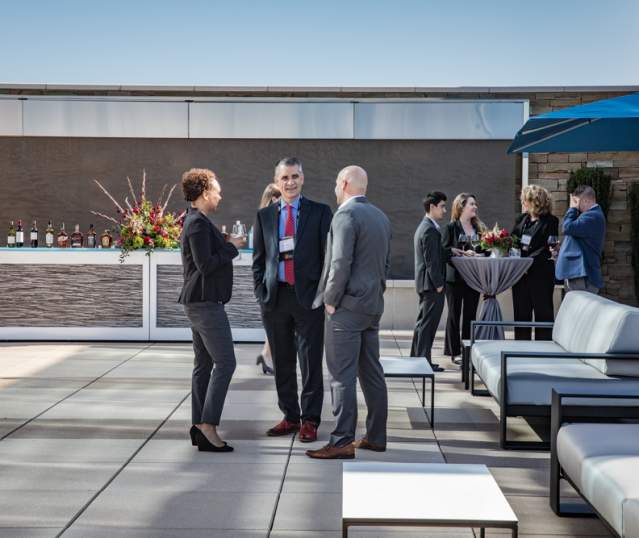 Group of conference attendees chatting on the terrace at City Springs