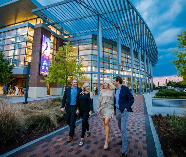 Couples walking in front of the Sandy Springs Performing Arts Center at City Springs.