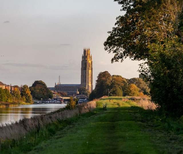 a church in the distance with a river running alongside