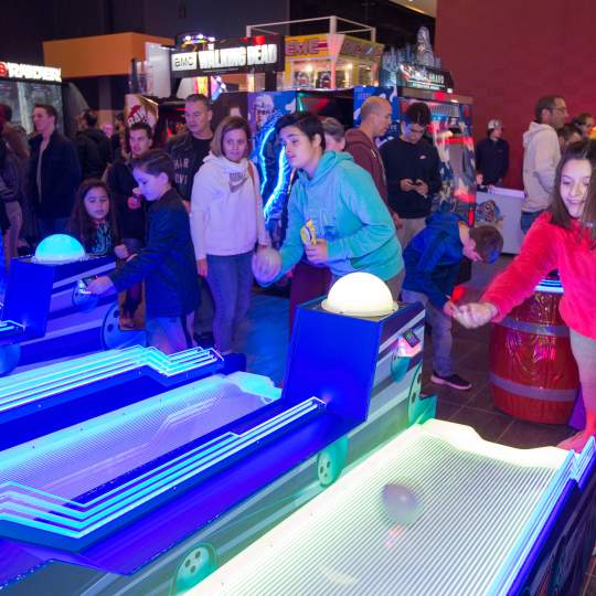 two kids playing skiball in an arcade