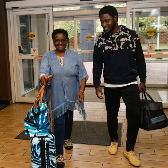 2 people walking into a hotel lobby