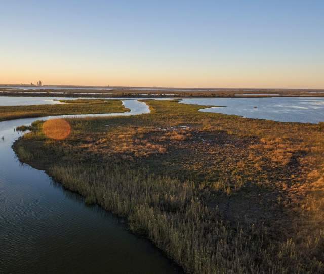 water and grass land masses at sunset