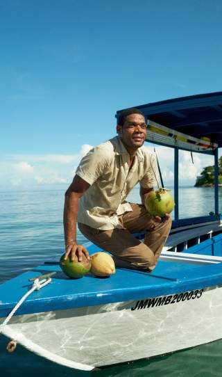 Man with Coconuts on Boat at Round Hill