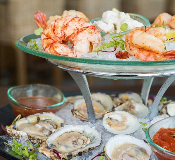Chilled seafood tower with oysters on the half shell, shrimp, lobster and more