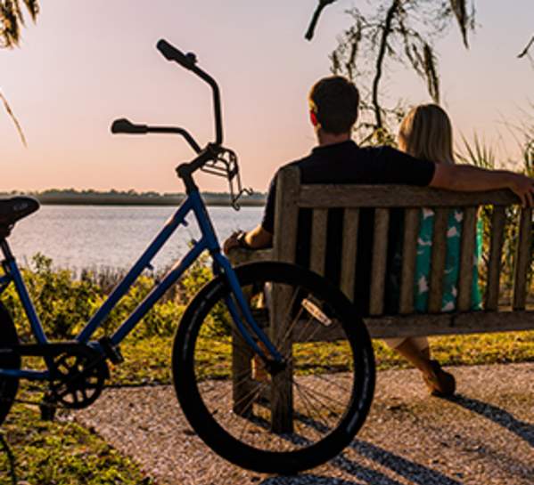 Bicycle Near Bench With Couple Over Looking Lake in Golden Isles