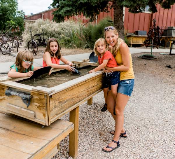 A mom and three kids pan for gold outside at the Frontier Homestead State Park Museum in Cedar City, Utah.