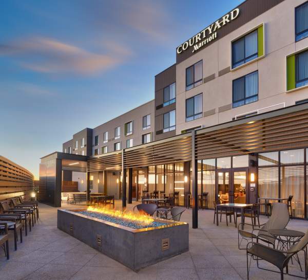 A group space on the patio at the Courtyard by Marriot in Cedar City with chairs and fireplace