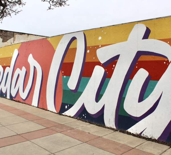 Brightly colored mural with a linear background and "Cedar City" written in white over the top.