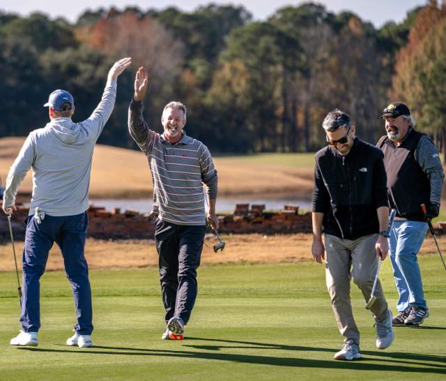 Group of golfers celebrating on the golf course.