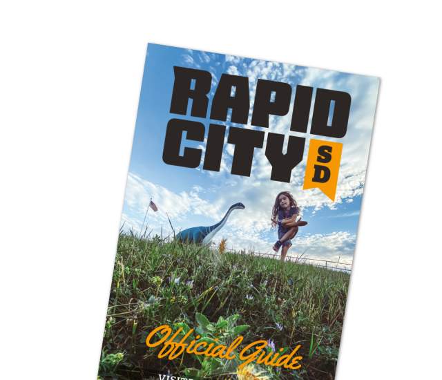 Image of the cover of the Rapid City Official Guide featuring dinosaur park