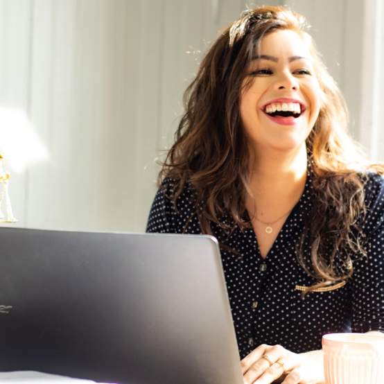 Woman smiling while working on laptop