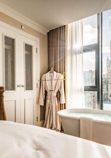 Hotel bedroom with bathtub and view to Manchester Town Hall