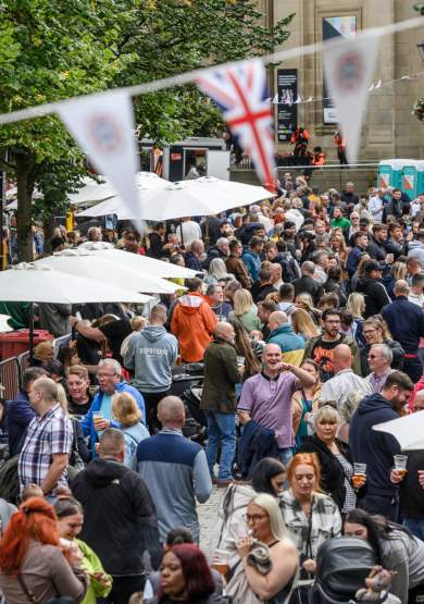 Group of people at a food and drink festival with stalls and bunting