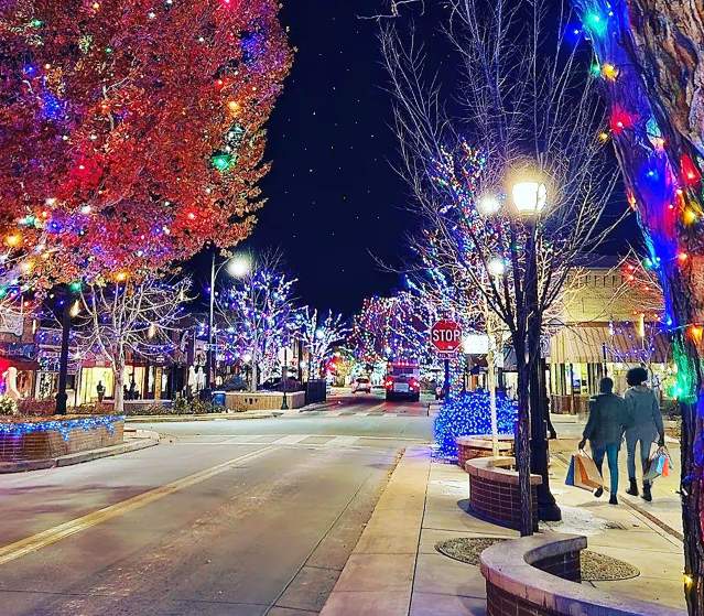Two People walking down Main Street with Twinkling Lights and Shopping Bags