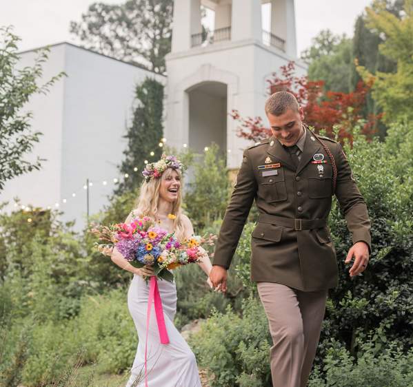 Bride and groom walking through landscaped gardens at Vizcaya Villa wedding venue in Cumberland County, North Carolina