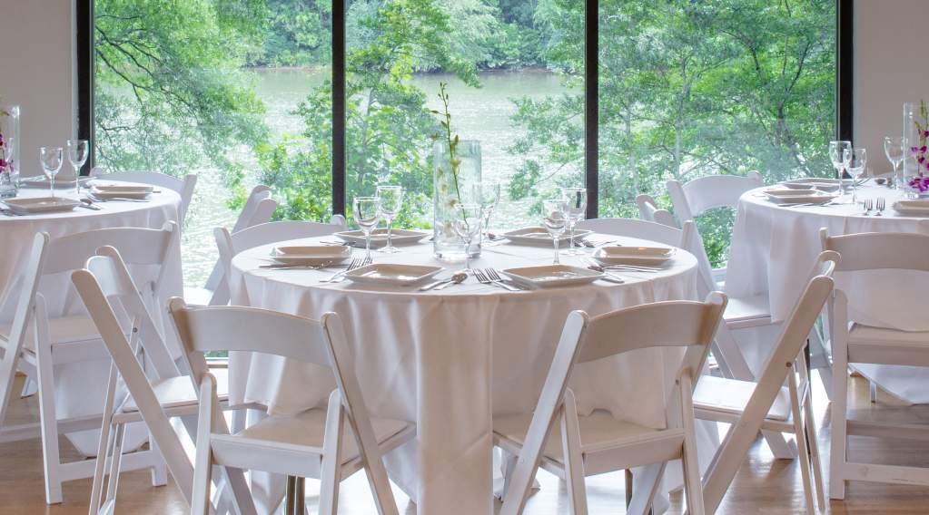 Tables dressed in white with white chairs for at a local Sandy Springs venue.