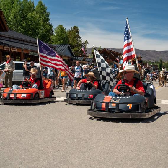 Go Karts with American Flags roll Grand Ave. in a parade