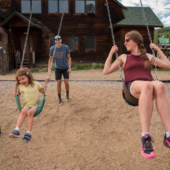 Family swinging on Grand Lake playground