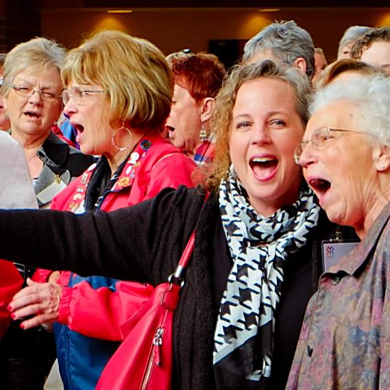 Group of Women Stand Together in Crowd with Mouths Open