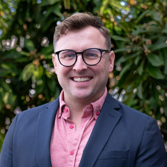 Picture of smiling person with wooded background