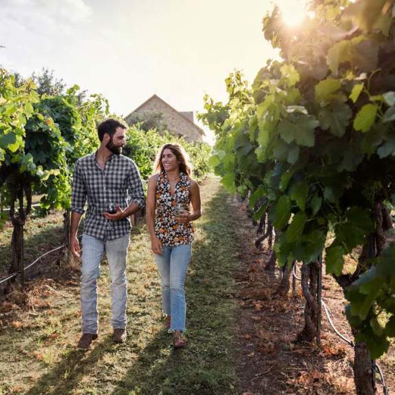 couple walking through vineyard