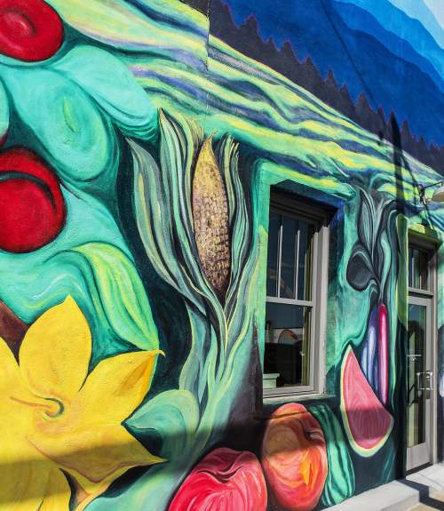 A mural of flowers, fruits, and veggies adorns the exterior of The Anchorage restaurant in Greenville, SC.