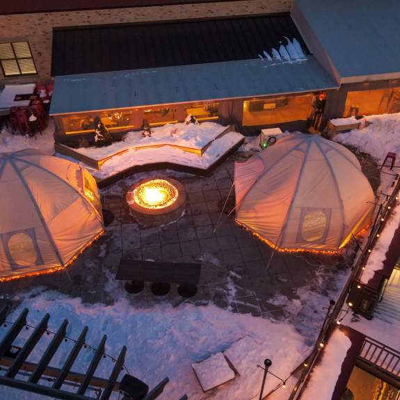 Aerial photo of two domes covered in snow outside on the patio of Lone Girl Brewing Company