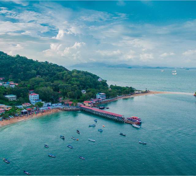 Aerial view of the town of San Pedro on Taboga Island, featuring the pier, beach, and tropical vegetation, Panama.