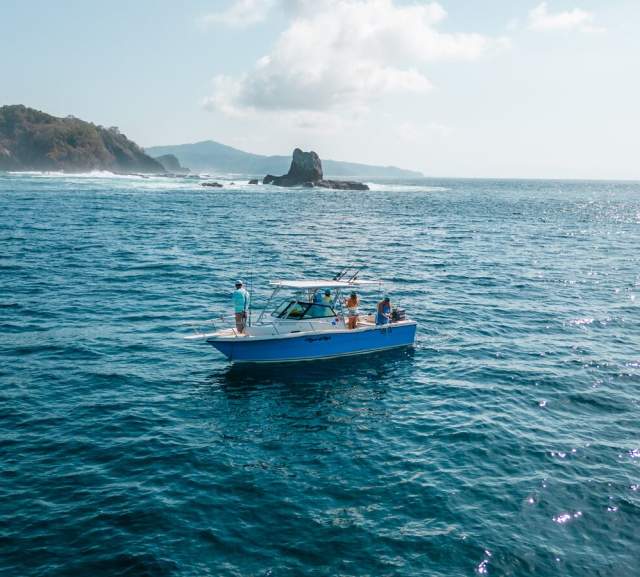 Sportfishing boat in Panamá’s coastal waters, with a mountainous landscape in the background and open sea ideal for world-class fishing
