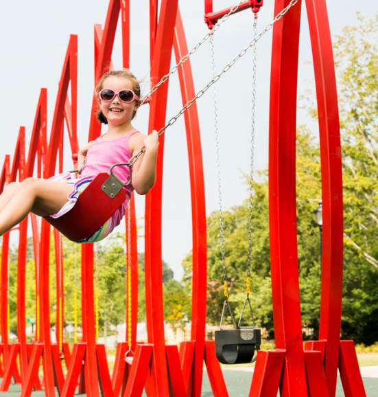 Red swings at the Abernathy Greenway Playable Art Park