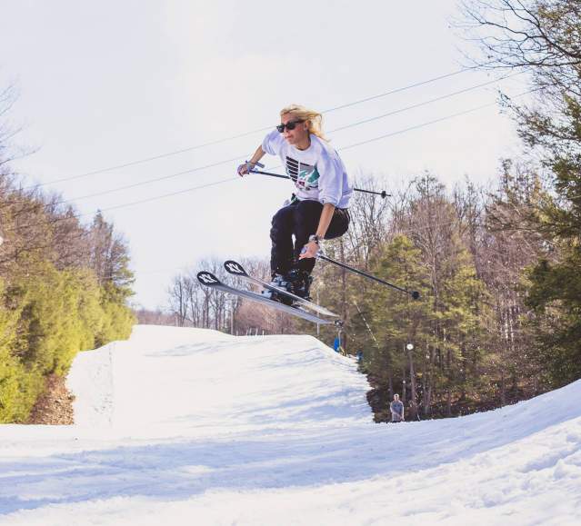 Skier jumping while skiing on snowy slope
