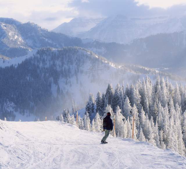 Snowboarder going down the Great Western at Brighton Resort, UT.