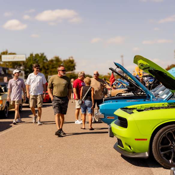 People viewing classic cars lined up during a Downtown Denison car show event