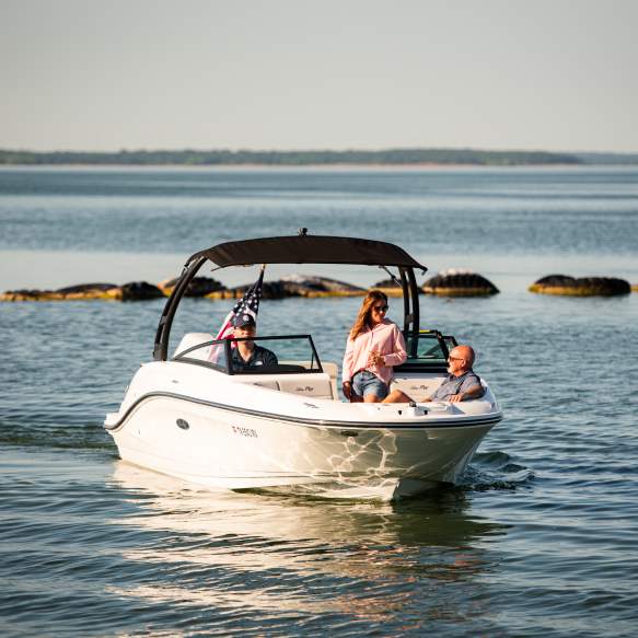 A couple enjoying a boat ride on a Freedom Boat Club boat driven by a staff member