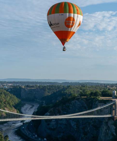 A green and orange striped balloon over the Clifton Suspension Bridge