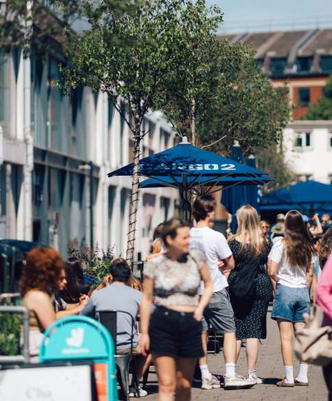 People walking alongside Cargo 2 shops in Wapping Wharf on Bristol's Harbourside - credit Shotaway