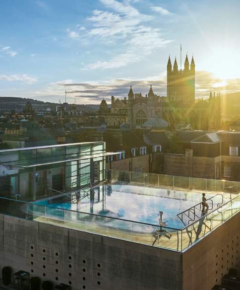An aerial view of the rooftop pool at the Thermae Bath Spa in central Bath, with Bath's skyline in the background