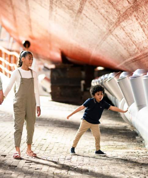 A family exploring the dry dock at Brunel's SS Great Britain, Bristol - credit Brunel's SS Great Britain