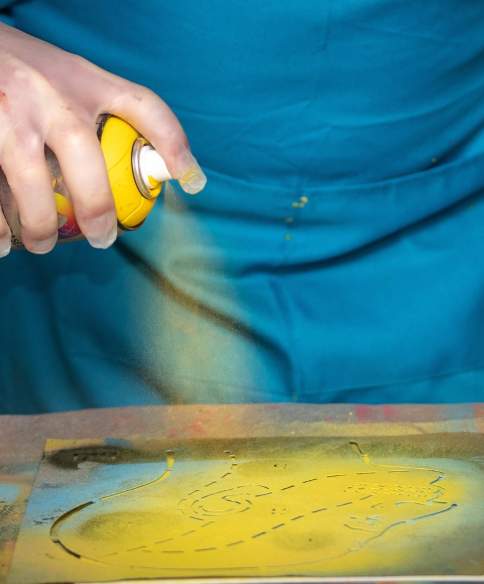 A person spraying a paint can onto a canvas at Graft Bristol - credit Yuup