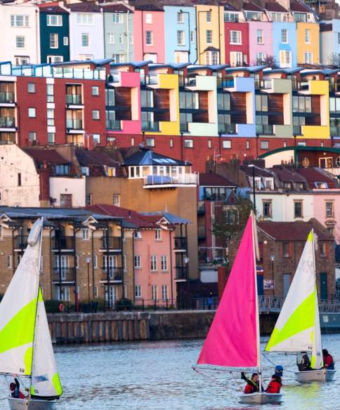 A view of small sailboats on Bristol's Harbourside with the colourful houses of Cliftonwood in the background - credit Paul Box