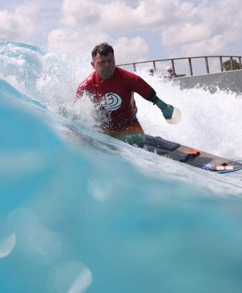 A surfer taking part in adaptive surfing at The Wave inland surfing lake near Bristol - credit The Wave