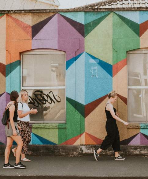 A tour guide leading a group past artworks painted during the Upfest street art festival in South Bristol