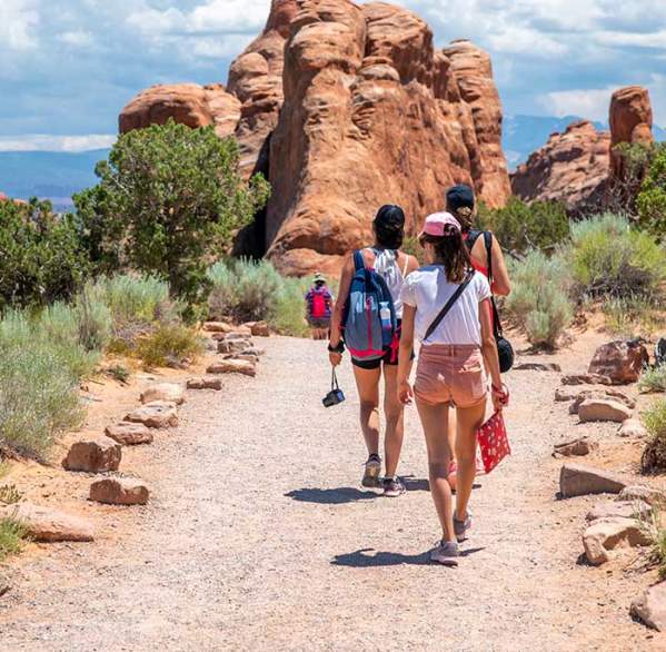 A group of women hikes amongst the towering red rocks of Arches National Park near Moab, Utah.
