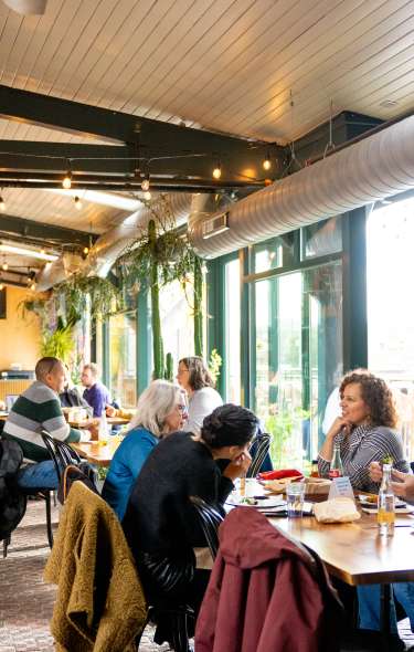 A photo of inside the restaurant, Bandit Tacos, where many people are sitting and enjoying their food.