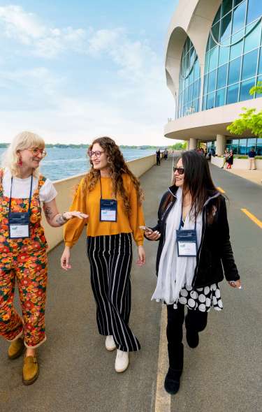Three meeting attendees walking along the path near Monona Terrace
