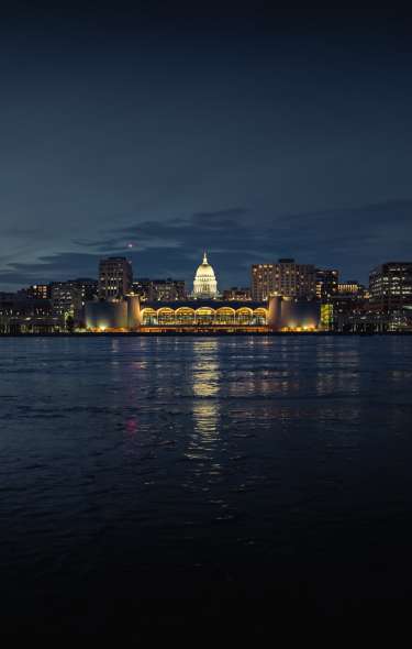A wide shot of the Madison skyline including the Capitol and Monona Terrace at night