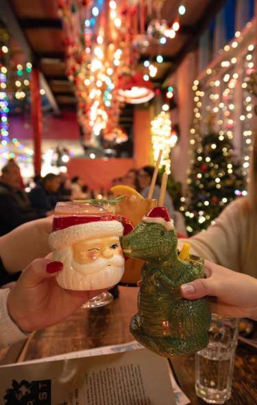Group of women cheers at Lucille with holiday-themed mugs